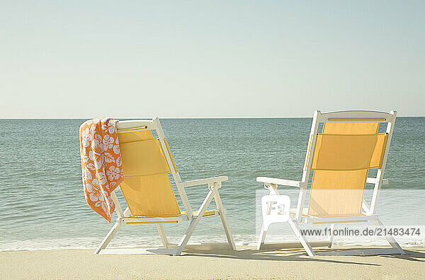 USA  Massachusetts  Nantucket  Two yellow beach chairs on sandy beach facing ocean