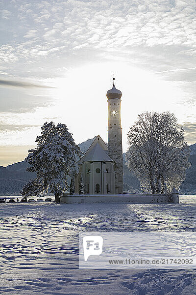 Blick auf Sankt Coloman in Schwangau im Winter mit Schnee  im Hintergrund die Allgäuer Alpen