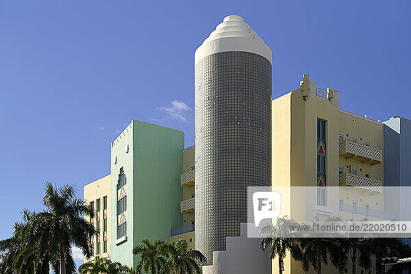 Colorful Art Deco building with a cylindrical glass block tower and palm trees under a blue sky  Miami  Florida  USA