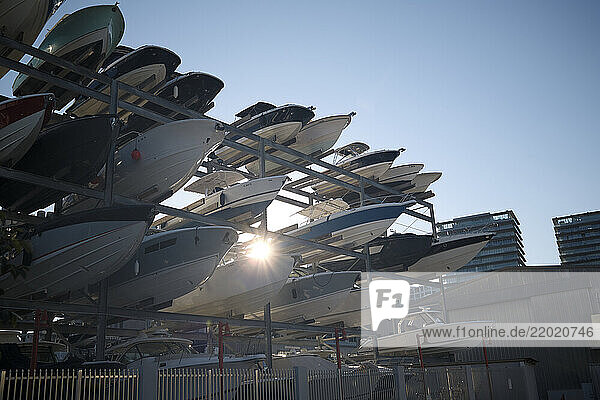 Stacked motorboats on metal racks with sunlight shining through in a marina setting  Miami  FLorida  USA
