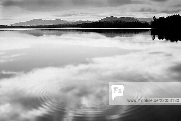 Clouds reflected in calm water surface  black and white
