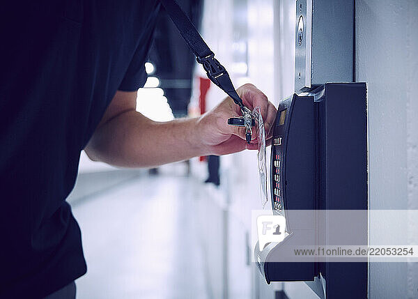 Close-up of employee using keycard and digital door lock in server room