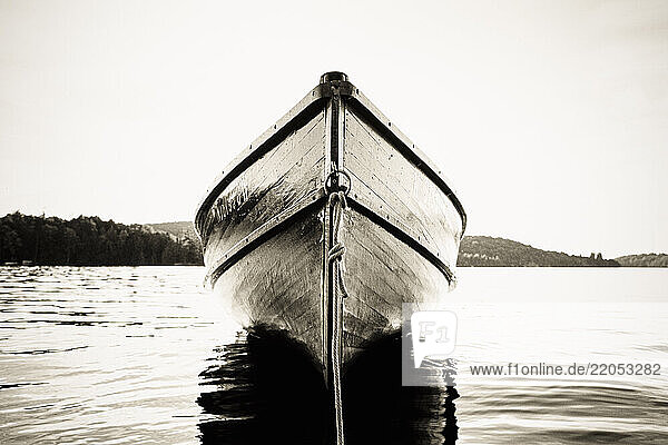 Wood boat anchored on Upper Saranac Lake  black and white
