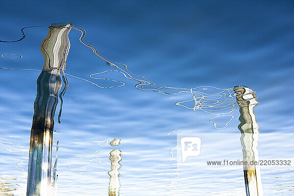 Pier pilings reflected in harbor rippled water