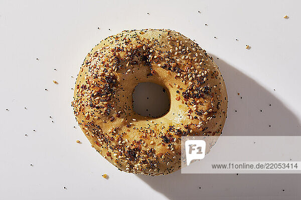 Overhead view of seeded bagel on white background