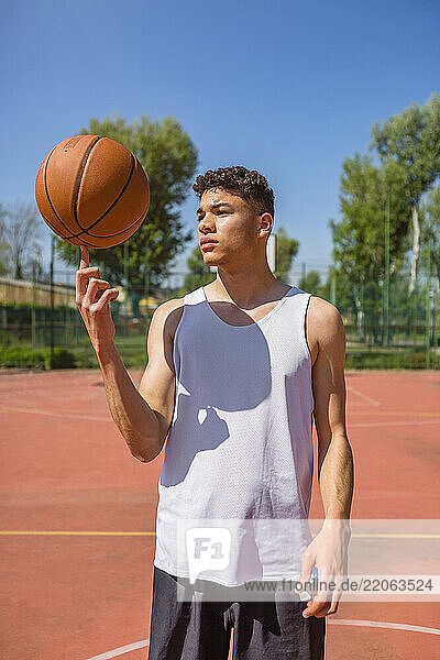 Young man playing with basketball