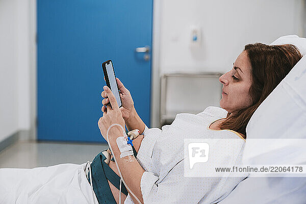Pregnant woman using mobile phone in delivery room