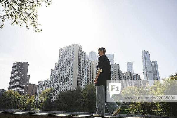 Short hair woman in black jacket with city view behind