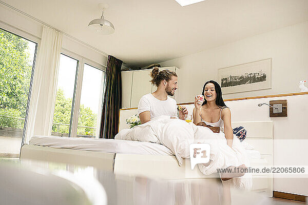 Affectionate couple having breakfast in bed