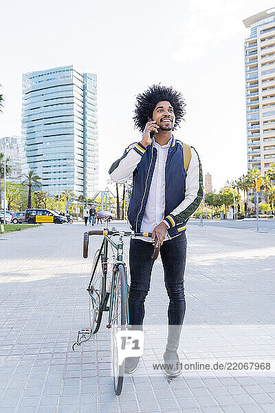 Casual businessman with bicycle on cell phone in the city  Barcelona  Spain