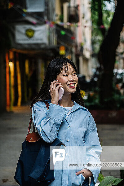 Woman talking on phone and smiling on a street in Barcelona