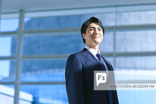 Japanese Businessman Standing In Front Of Building