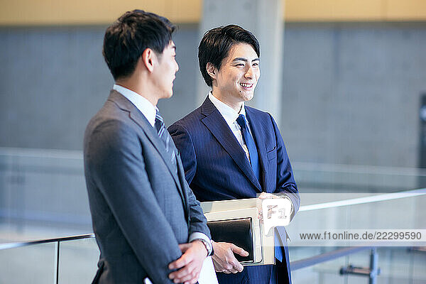 Two Japanese Businessmen Standing In An Office