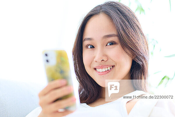 Japanese Woman Smiling While Holding A Cell Phone