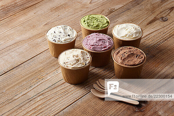 A Group Of Ice Cream In Cups On A Wooden Table