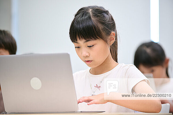 A Young Girl Using A Laptop Computer