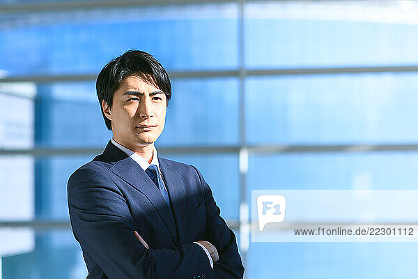 Japanese Businessman Standing In Front Of A Window