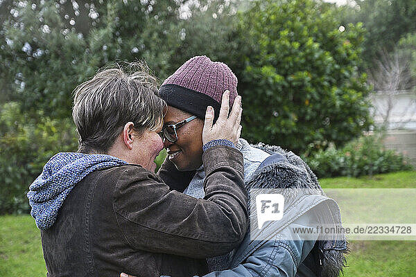 Lesbian couple embracing in garden
