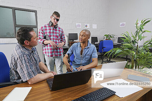 Group of businessmen working at desk in office