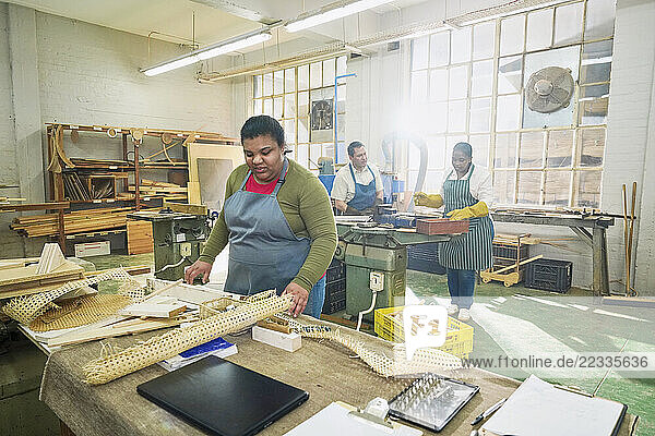 Group of craftsmen working in woodshop