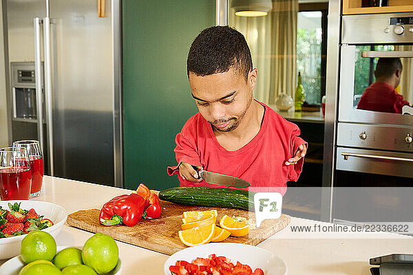 Man with phocomelia cutting vegetables