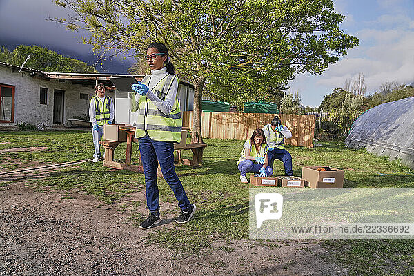 Group of volunteers packaging donation boxes outdoors