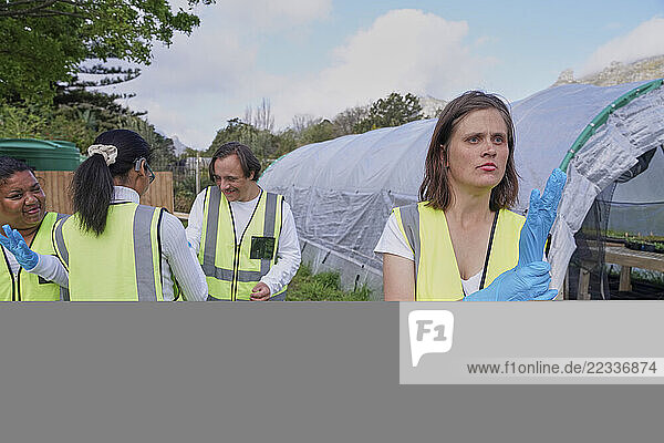 Group of volunteers standing near greenhouse outdoors