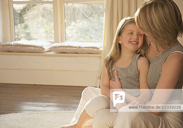 Mother hugging smiling daughter