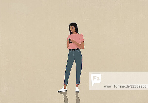 Young woman texting with smart phone on beige background