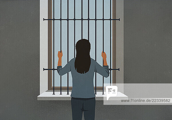 Woman standing behind bars looking out window