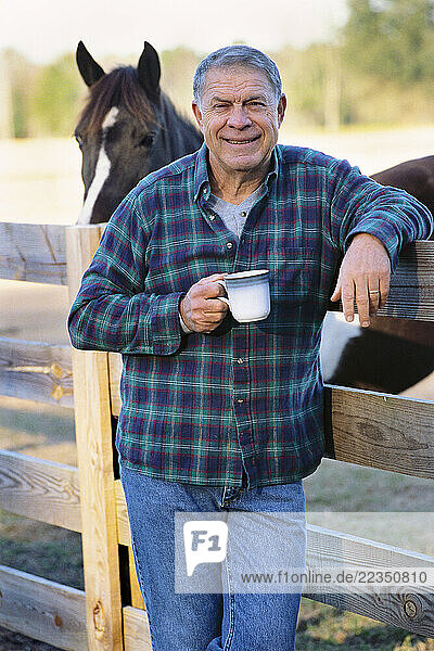 Man Leaning on Fence