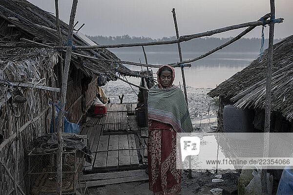 Woman stands in a hanging village in the deep forest area at Kalabogi in Dacope  Sundarban Bangladesh on February 12  2020. Cyclones  floods  and erosion are common for them. Bangladesh projected to lose nearly 2 270 hectares of land this year to riverbank erosion; Khula  Dhaka  Bangladesh