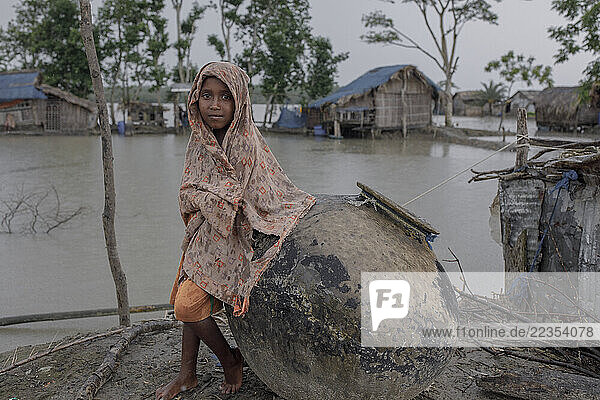 Portrait of a boy at the Kalabogi village in Khulna  Bangladesh  on 18 April 2023. In the coastal areas of Southern Bangladesh like Kalabogi  people‘s livelihoods depend entirely on nature. Climate change has severe impacts on the natural environment. The consequences range from rising sea levels leading to salinization of soils and groundwater to erratic rainfall patterns and more frequent and destructive tropical cyclones. People living in coastal areas fight for their survival every day; Khulna  Dhaka  Bangladesh