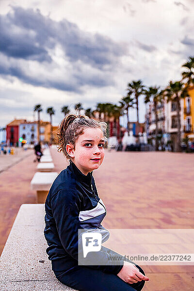Child sitting on the beach promenade in Villajoyosa