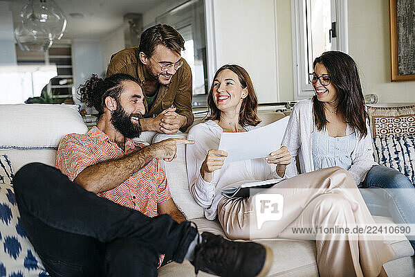 Coworkers and friends sitting on couch with papers