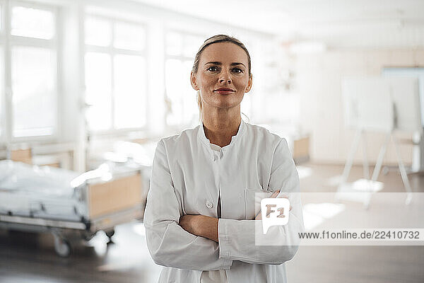 Doctor standing confidently in a clinic patient room