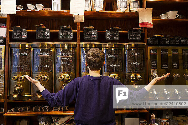 Roastery owner confidently showcasing coffee selection in a small business setting