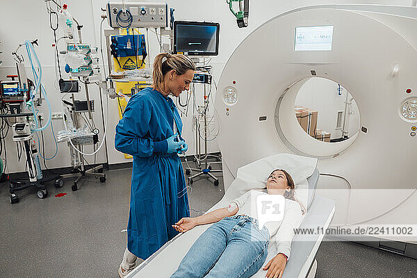 Doctor consulting patient in an emergency room with MRI machine