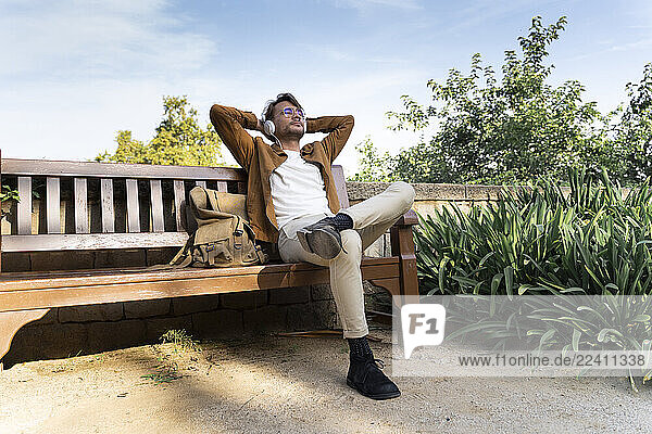 Man sitting on bench listening music with headphones