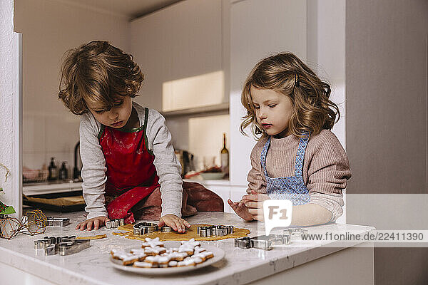 Two girls preparing Christmas cookies in kitchen