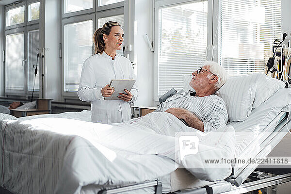 Doctor consulting with patient in hospital room during the day