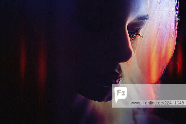 Artistic portrait of a woman with neon lighting and reflections