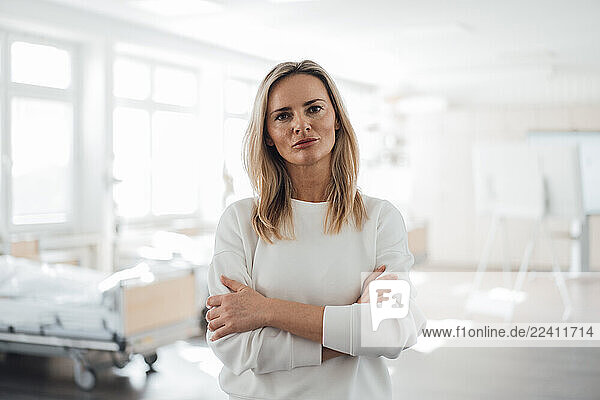 Doctor standing confidently in a clinic patient room