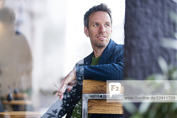 Businessman working remotely in a café looking away