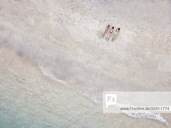 Aerial view of young women lying at the beach  Gili Air island  Bali  Indonesia