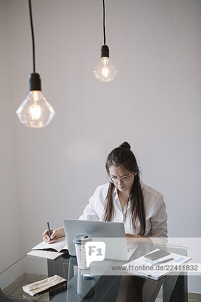 Young woman working at table in office