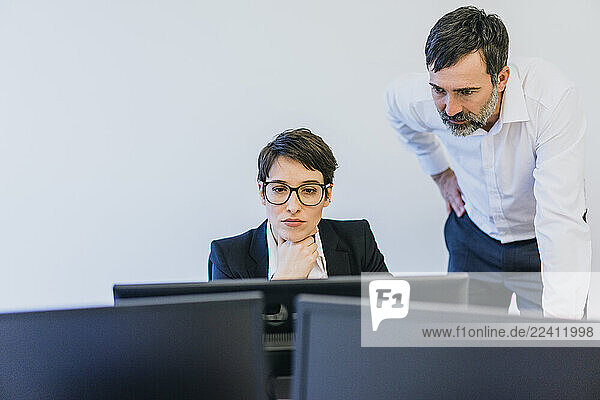 Businessman and employee at desk in office
