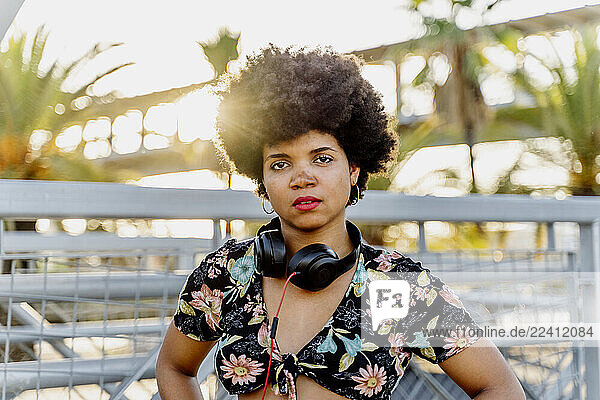 Female Afro-American with headphones against the sun