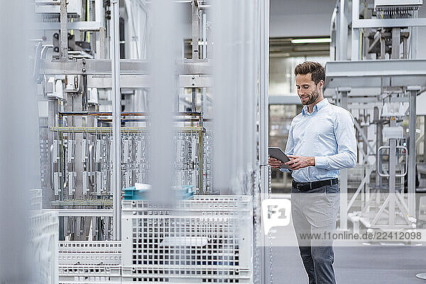 Businessman using tablet in a modern factory