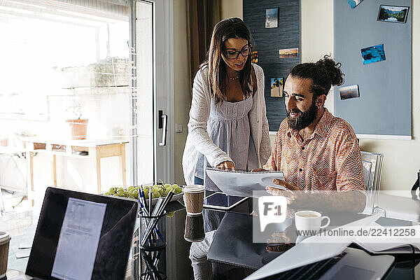 Man and woman working together on table at home